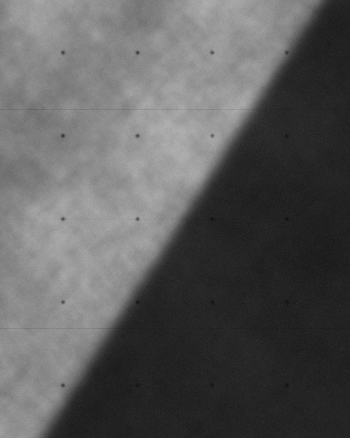 Board-formed concrete wall cut by a diagonal shadow